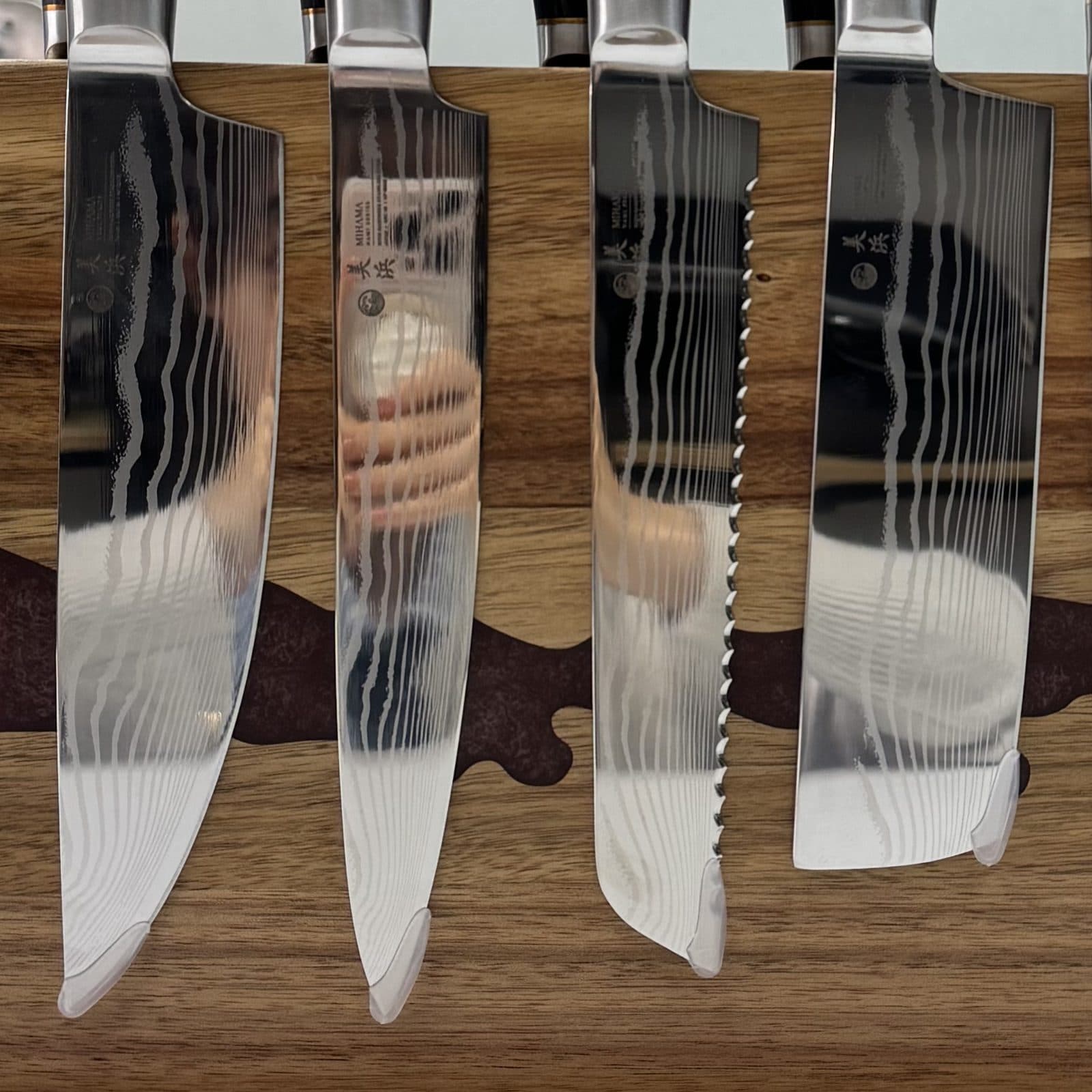 The Nami six-piece Damascus knife set on its magnetic wood stand